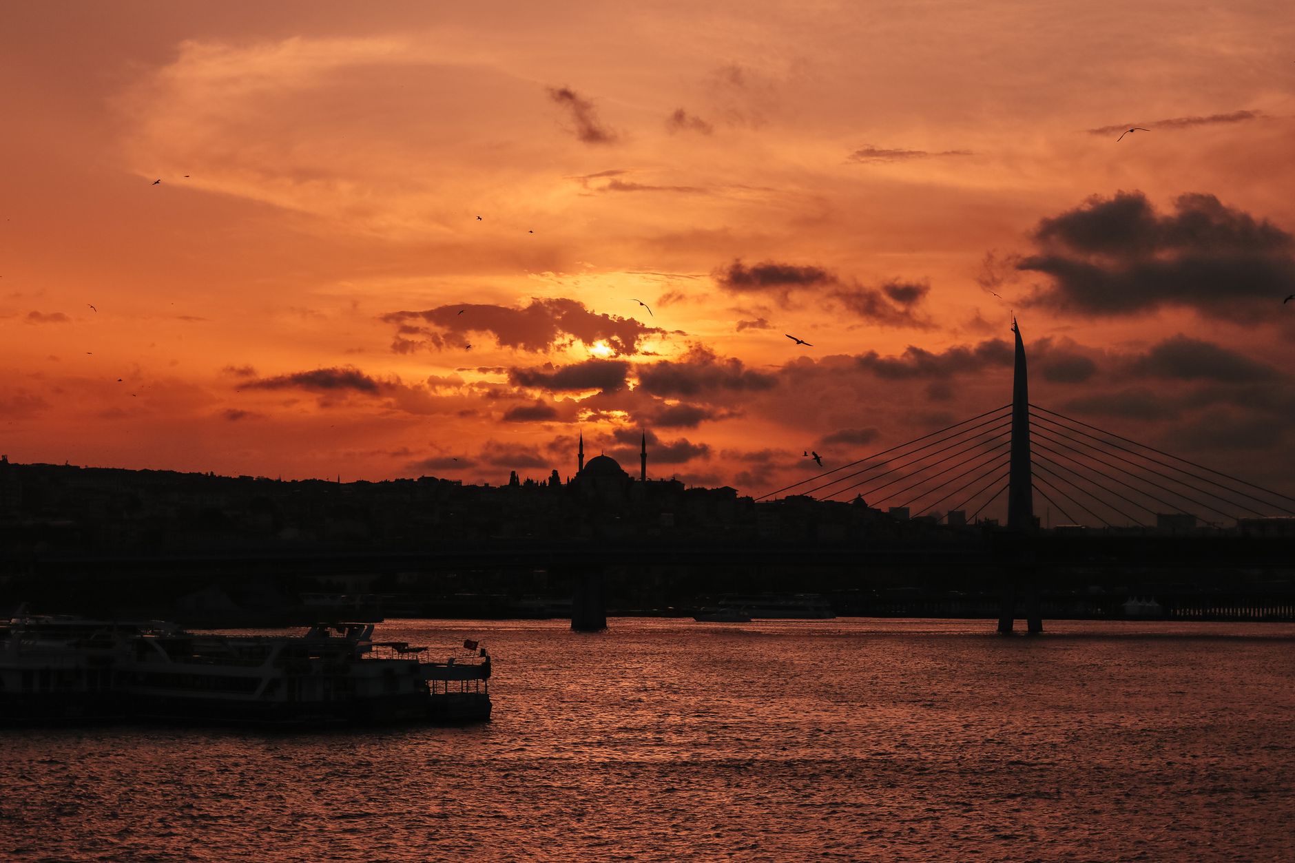 A stunning sunset over a bridge, creating a dramatic silhouette on the water.. stunning, sunset, over