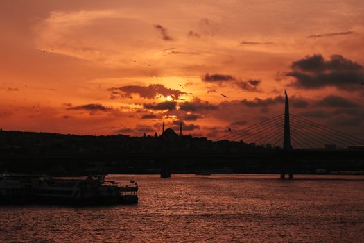 A stunning sunset over a bridge, creating a dramatic silhouette on the water.. stunning, sunset, over