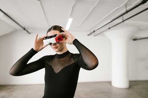 Woman in Black Long Sleeve Shirt Holding and Using Virtual Reality Glasses