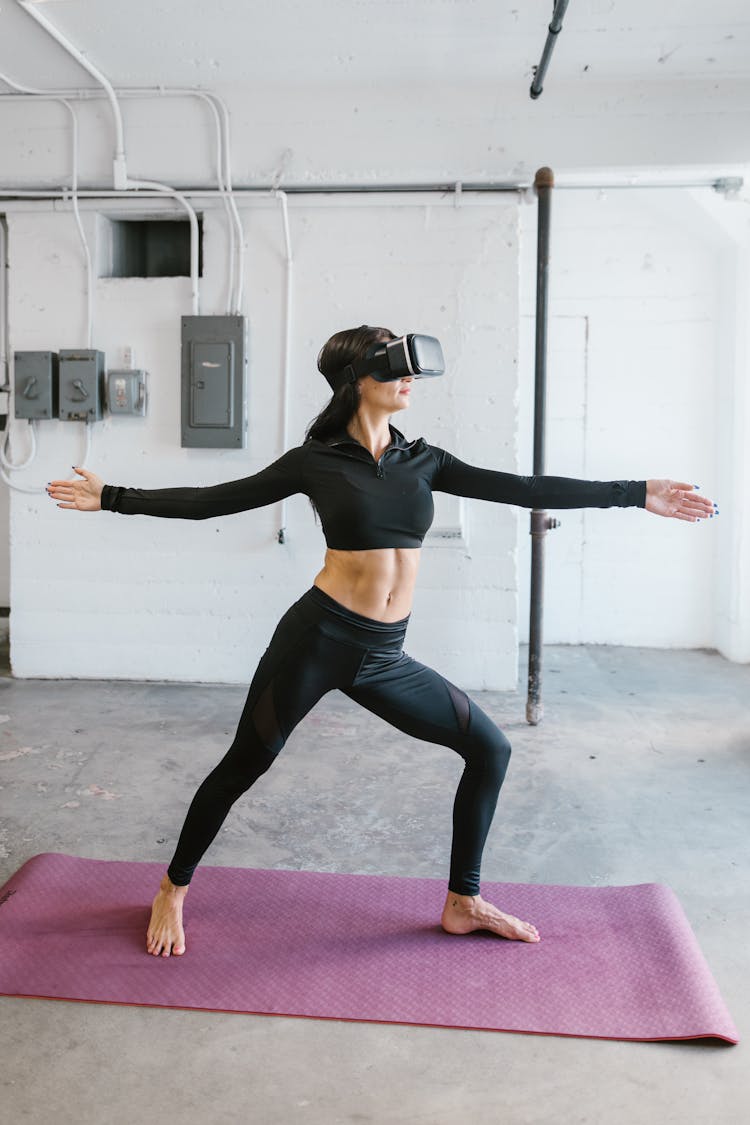 Woman With Virtual Reality Goggles On A Yoga Mat