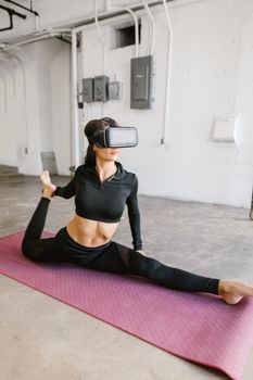 A woman in sportswear performs yoga with a VR headset indoors, promoting virtual fitness.