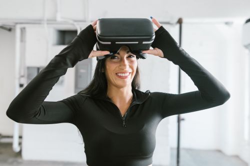 Free Excited woman trying virtual reality headset indoors, smiling with joy. Stock Photo