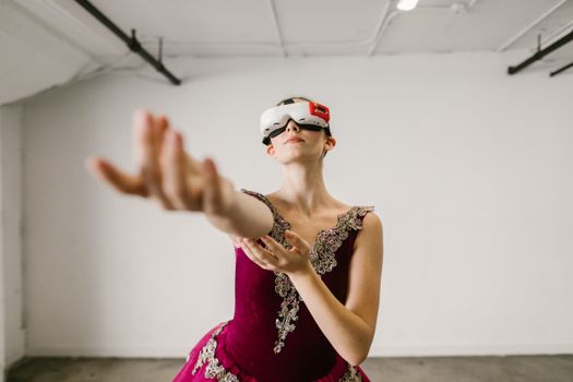 Ballerina gracefully dancing indoors while wearing a VR headset, combining tradition with virtual reality.