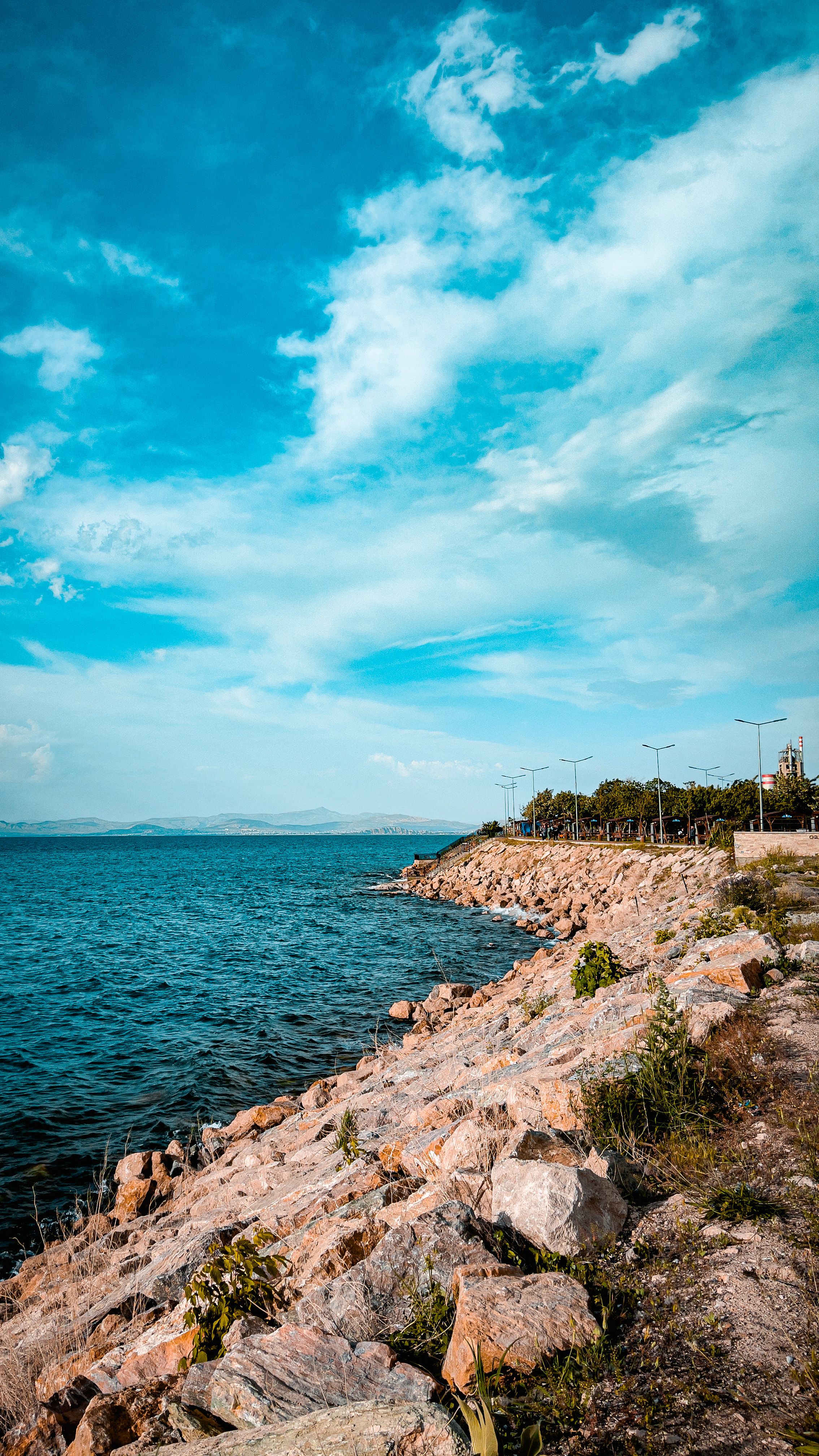 Stunning view of a rocky shoreline under vibrant blue skies, perfect for nature lovers.