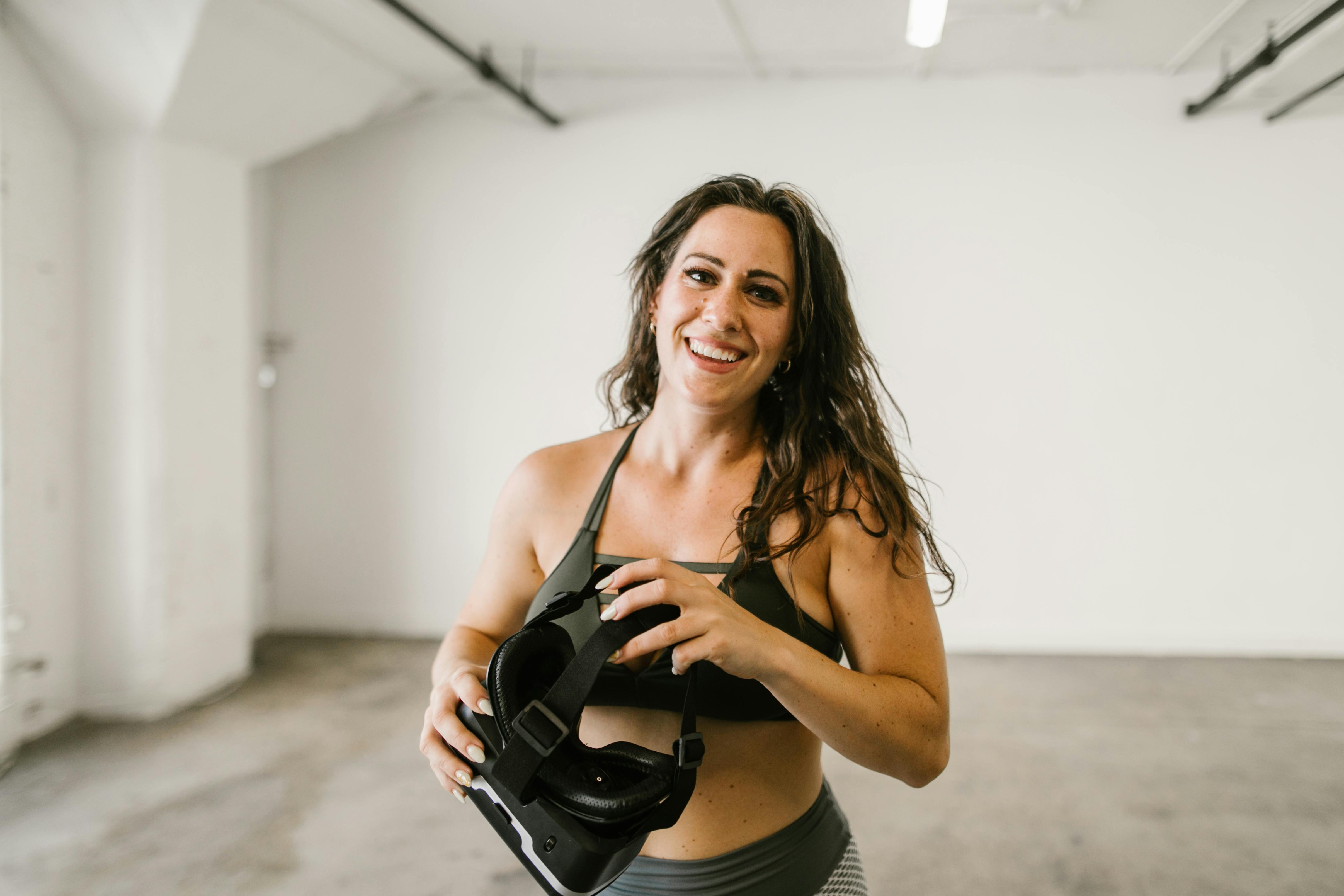 woman in sports bra holding a virtual reality headset