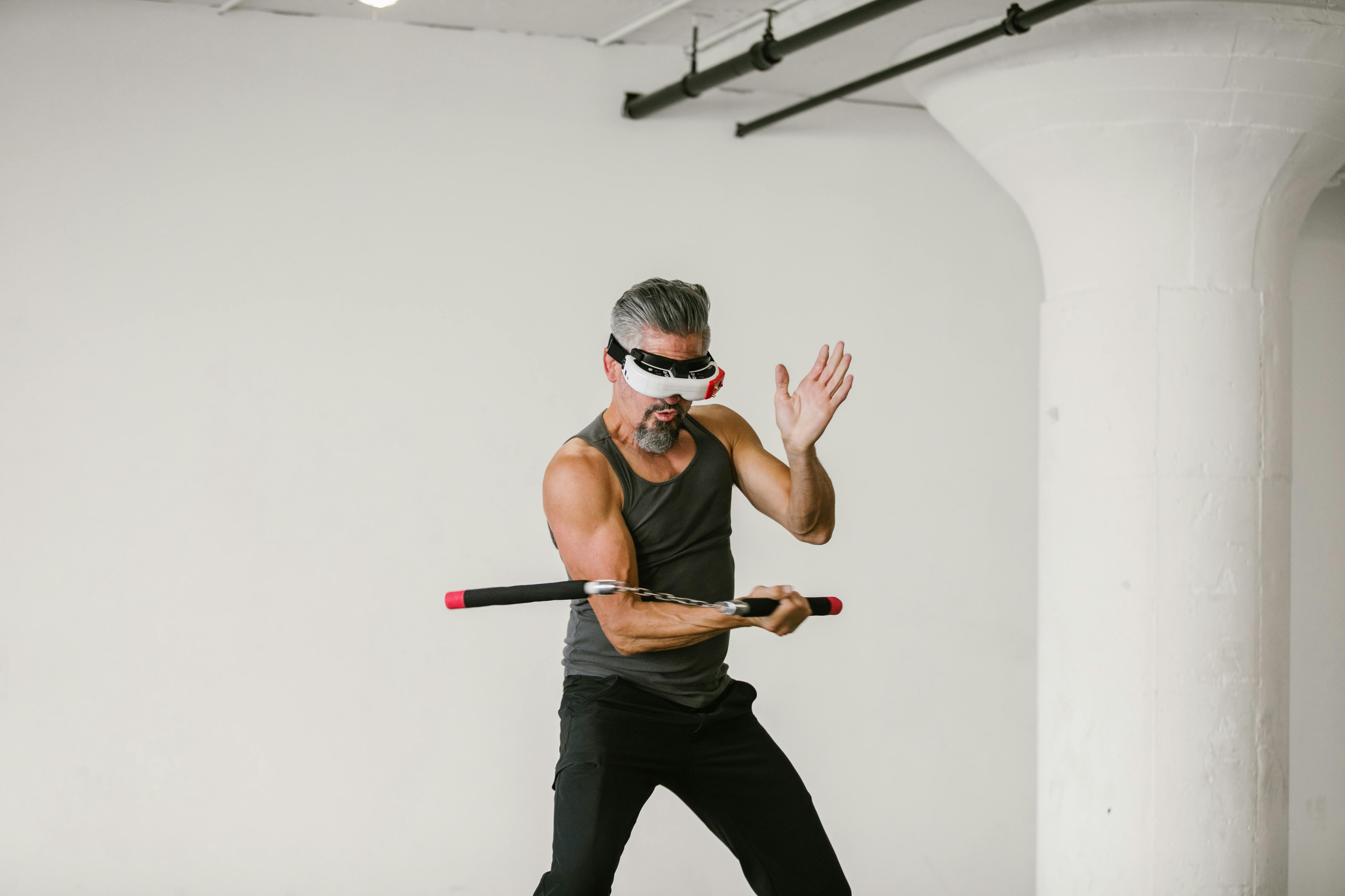 man using nunchaku while wearing virtual reality glasses