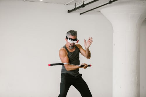 Free Man using Nunchaku while wearing Virtual Reality Glasses Stock Photo
