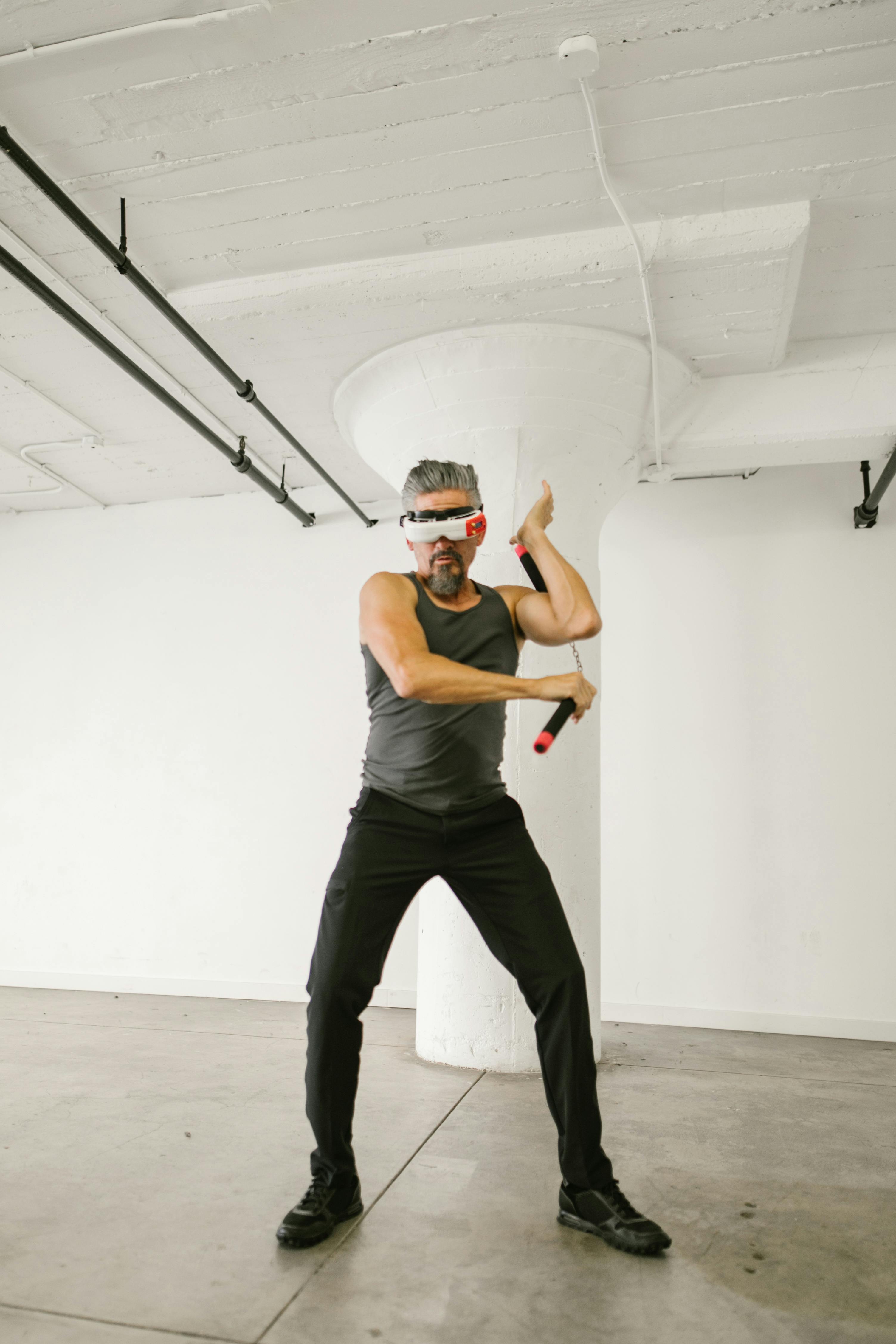 man using nunchaku while wearing virtual reality glasses