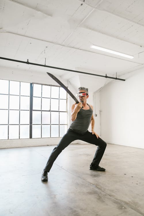 Free Man Holding a Sword while Using Virtual Reality Headset Stock Photo