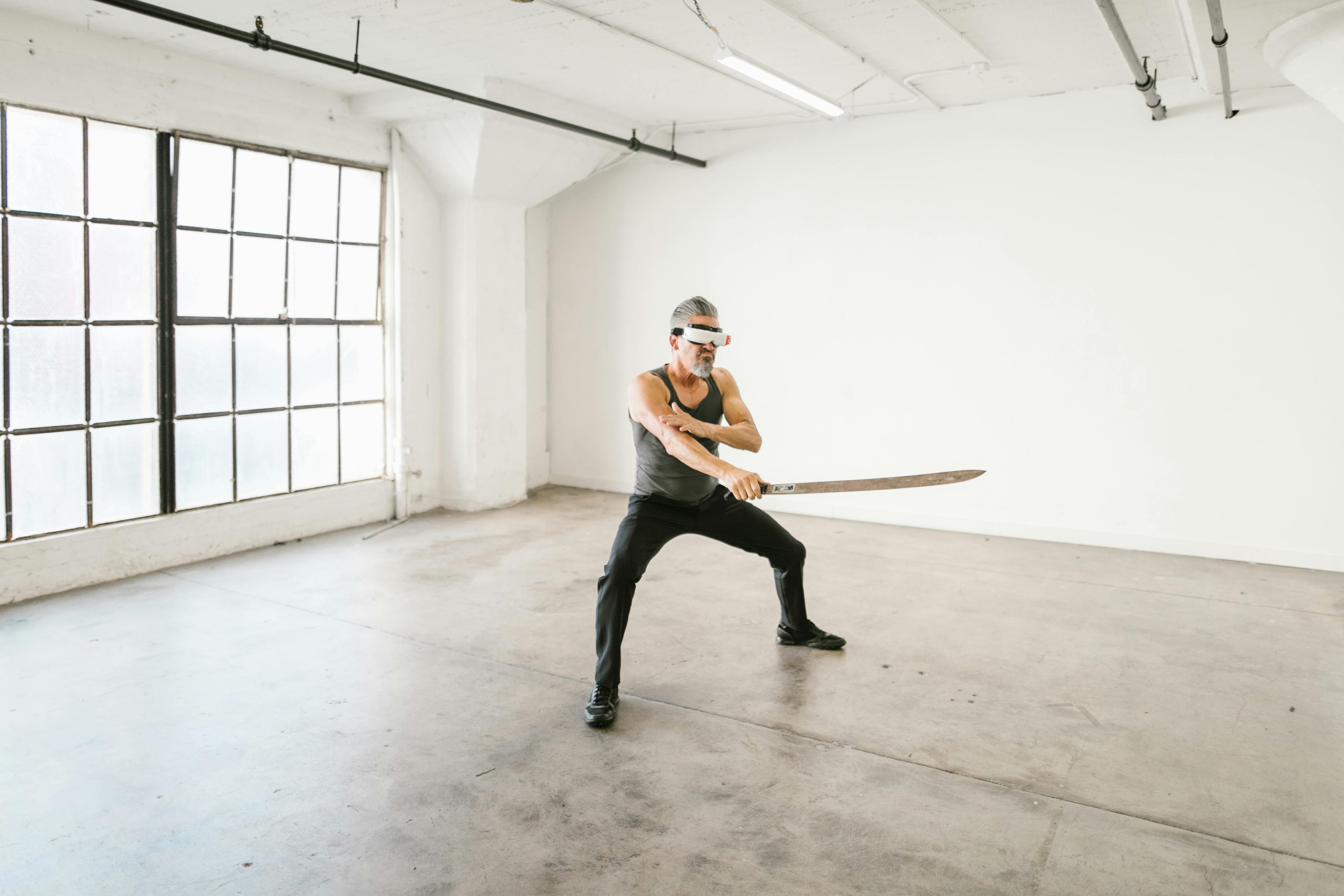 man in gray tank top holding a sword