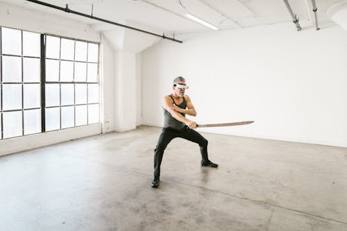 Free Man in Gray Tank Top Holding a Sword Stock Photo
