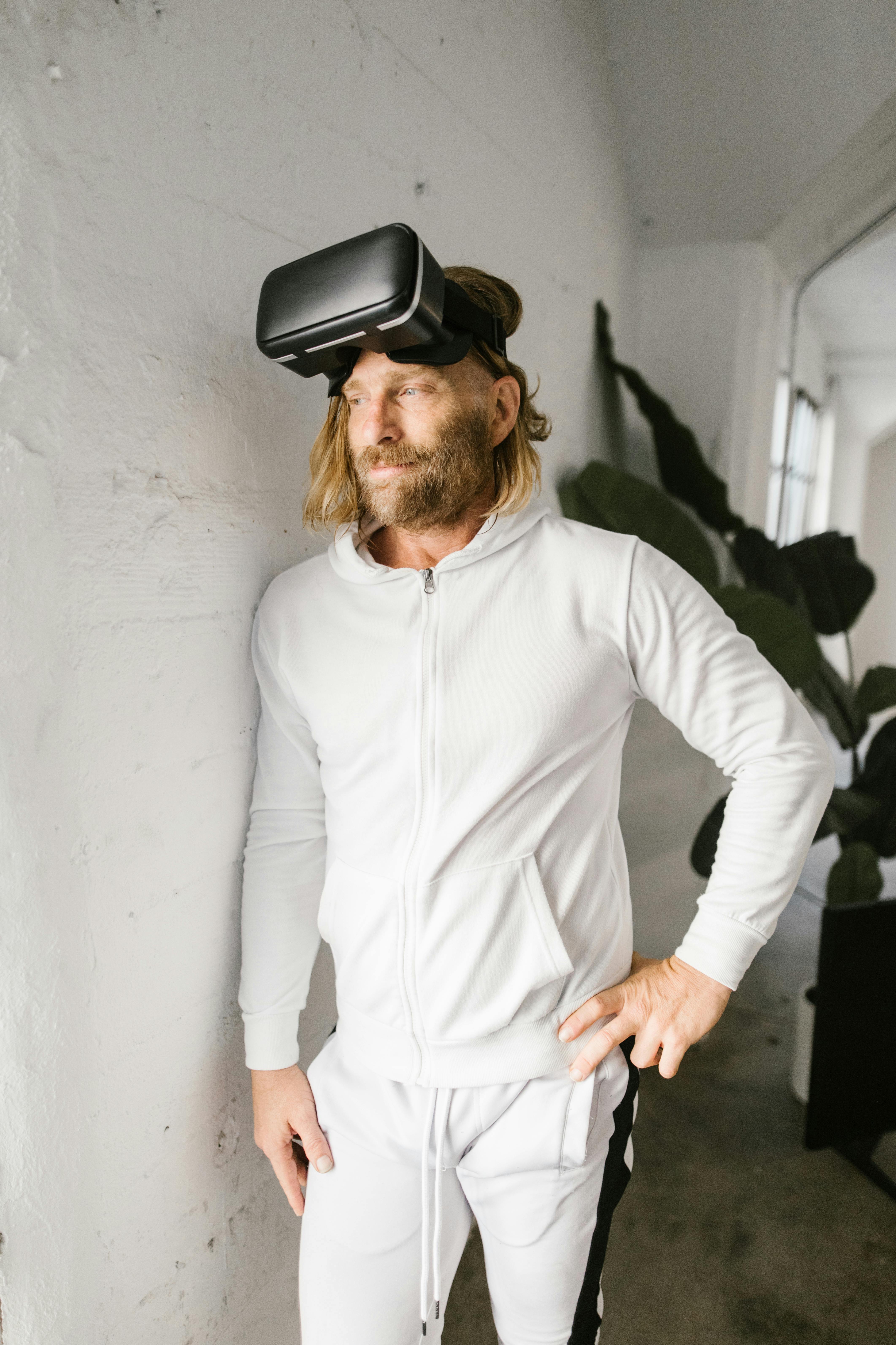 Man wearing VR headset standing indoors, engaged in virtual reality experience.