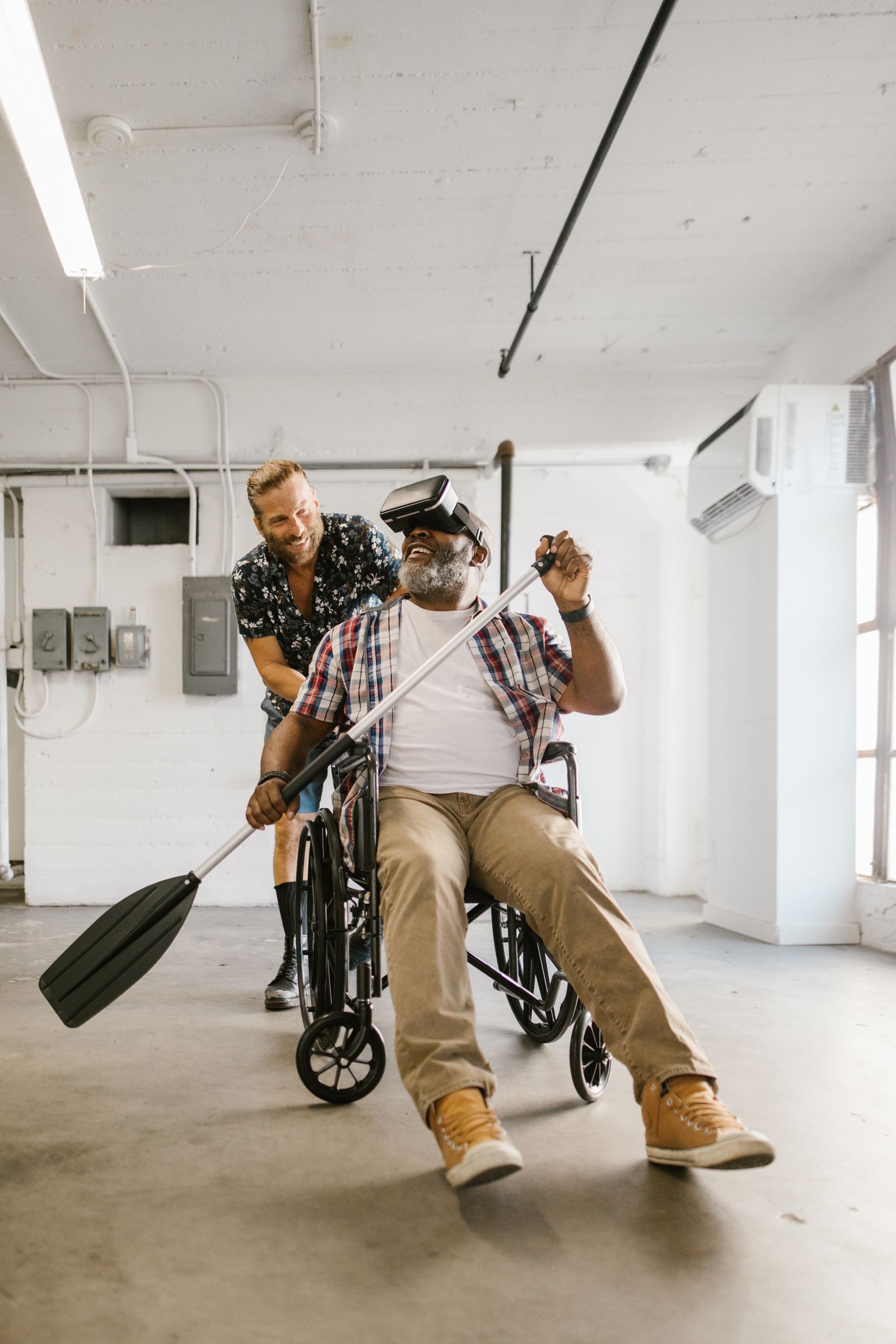 A wheelchair user taking part in an immersive virtual reality experience with another participant nearby.