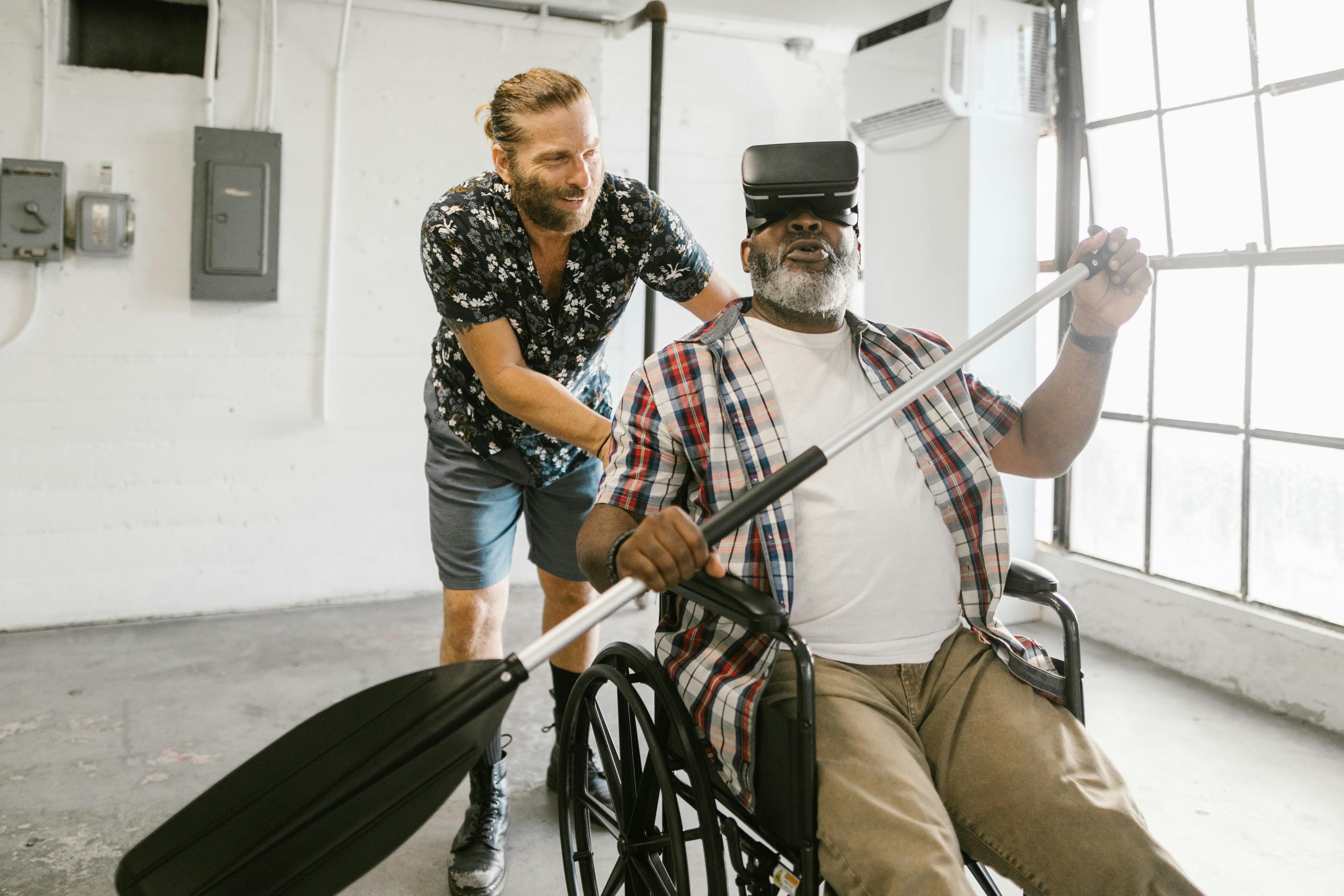 man helping a man play with virtual reality headset