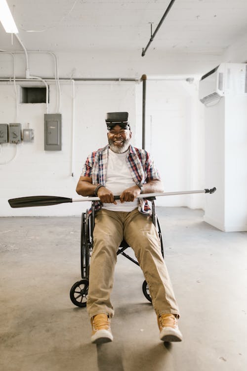 Free Man sitting on a Wheelchair while wearing Virtual Reality Glasses Stock Photo