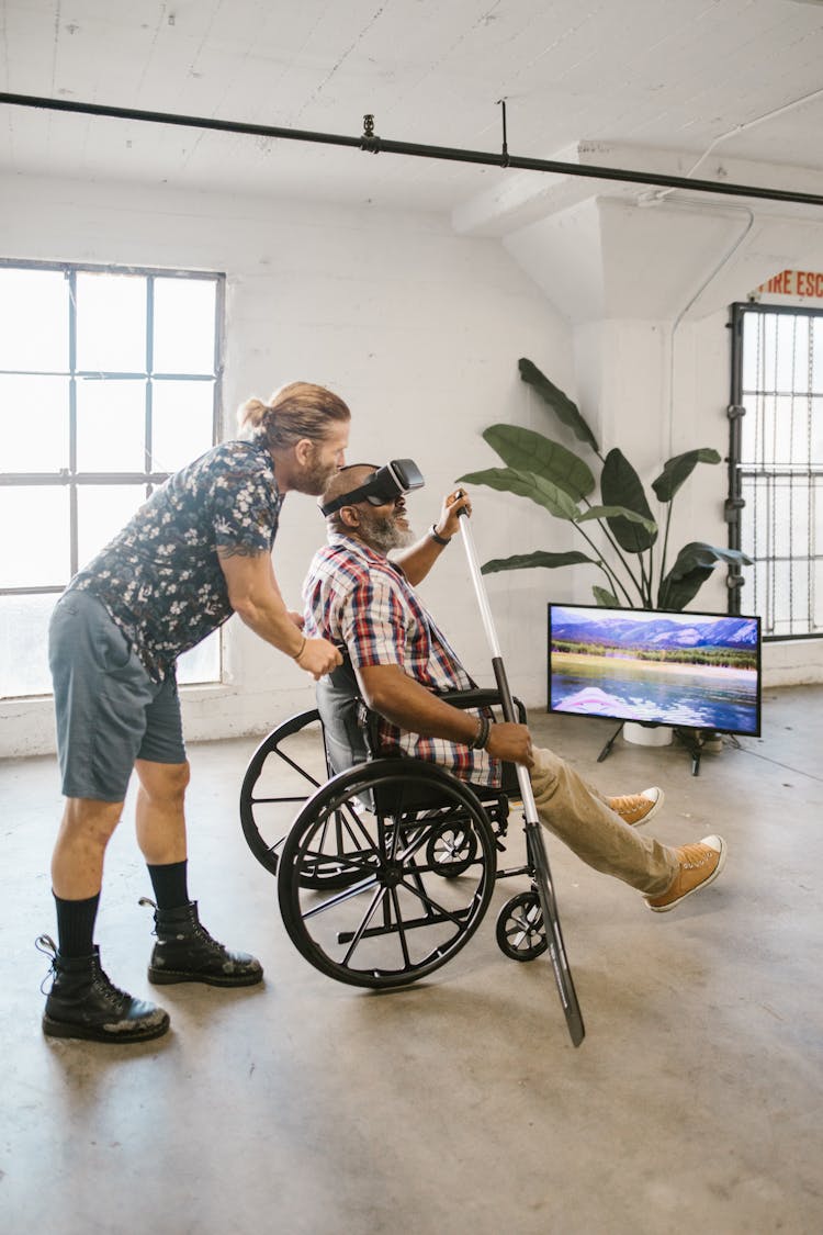 A Man Pushing Another Man On A Wheelchair