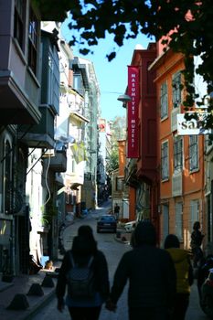 Scenic view of a narrow cobblestone street with people walking towards the Masumiyet Museum in Istanbul.