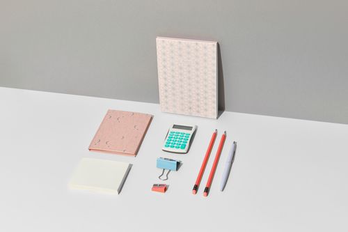 Free Flat lay of a neat stationery set including a calculator, pencils, and notebooks. Stock Photo