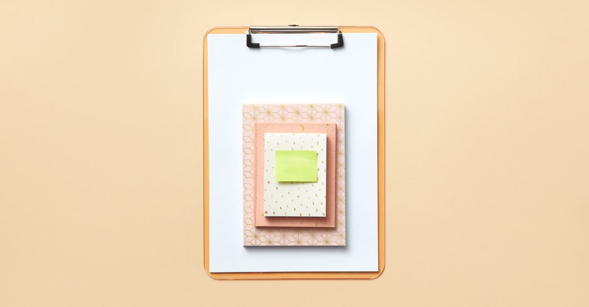 A clipboard with a checklist beside a notebook representing what to look for in an SEO competition tracker