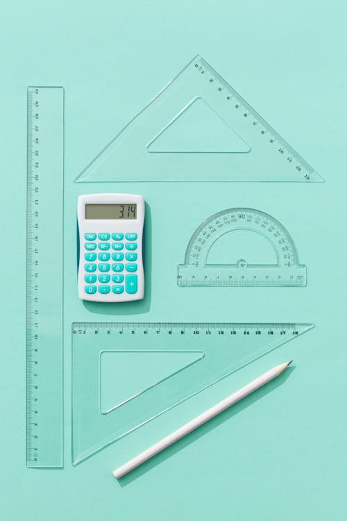 A White Pen and Calculator Beside Some Rulers