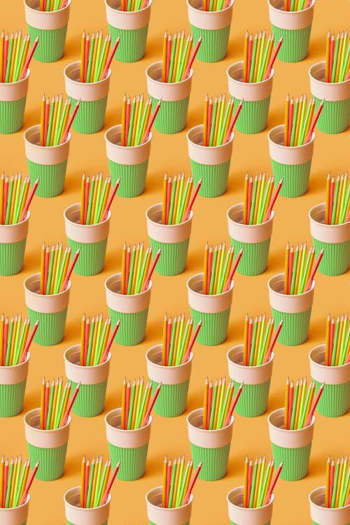 Green and White Plastic Cups With Colored Pencils