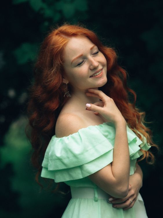 Dreamy woman with red hair in green dress standing in garden  Free Stock  Photo