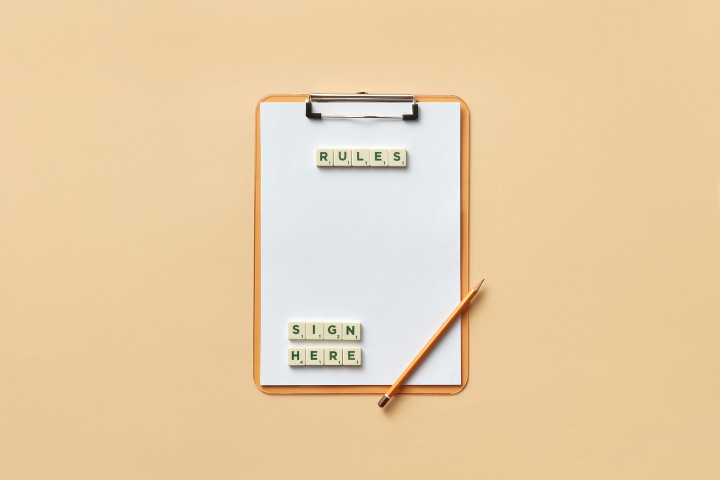Flat lay of clipboard with letter tiles spelling 'rules' and 'sign here', accompanied by pencil on beige background.
