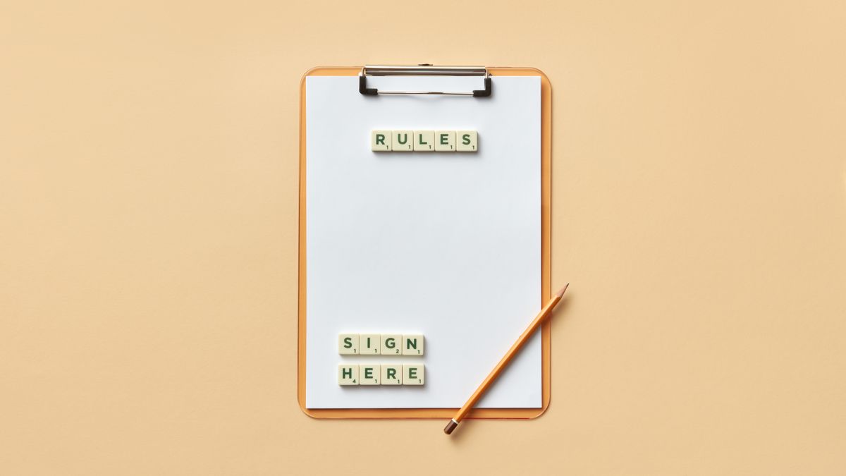 Flat lay of clipboard with letter tiles spelling 'rules' and 'sign here', accompanied by pencil on beige background.