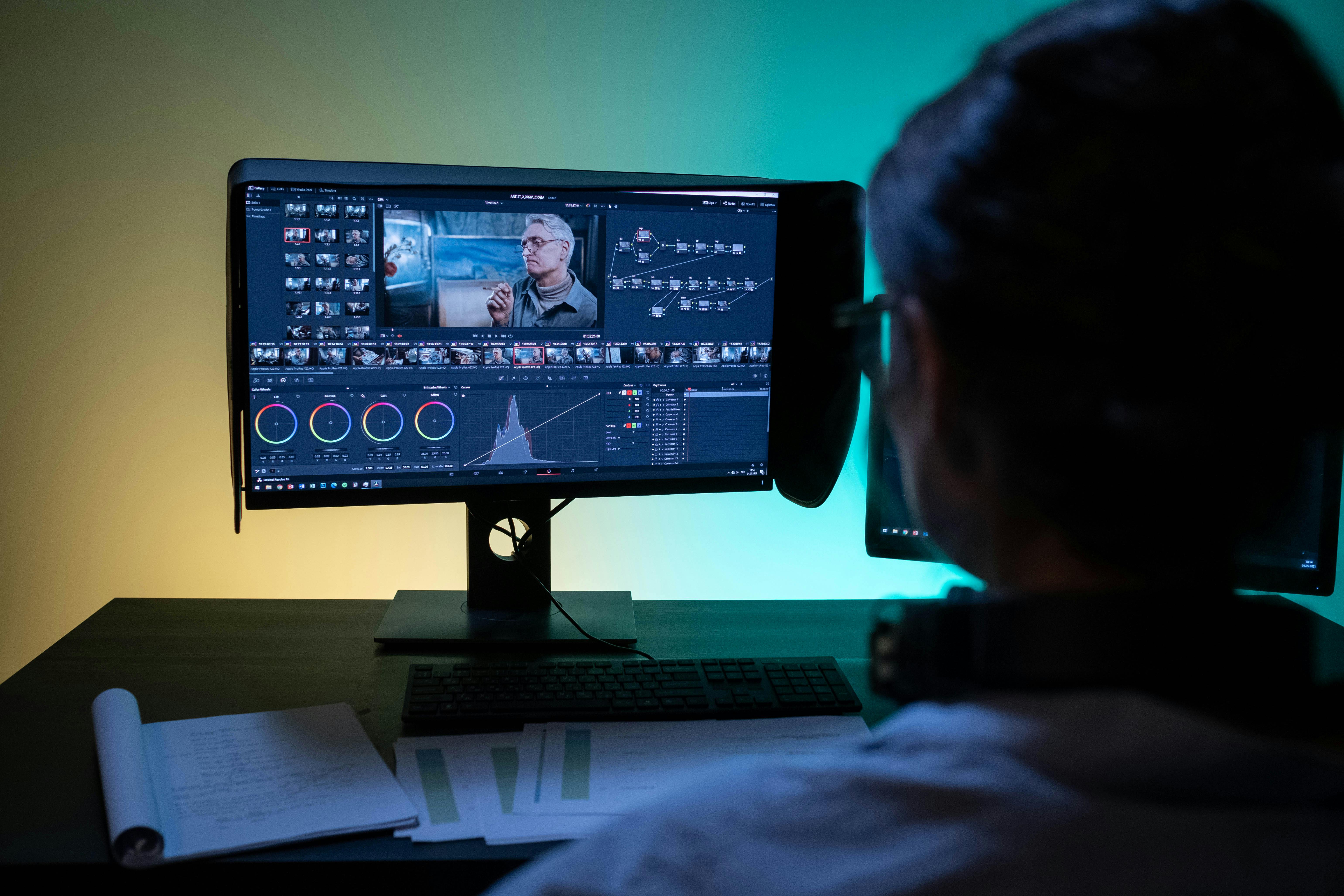 Woman working remotely on video editing in a dimly lit room.