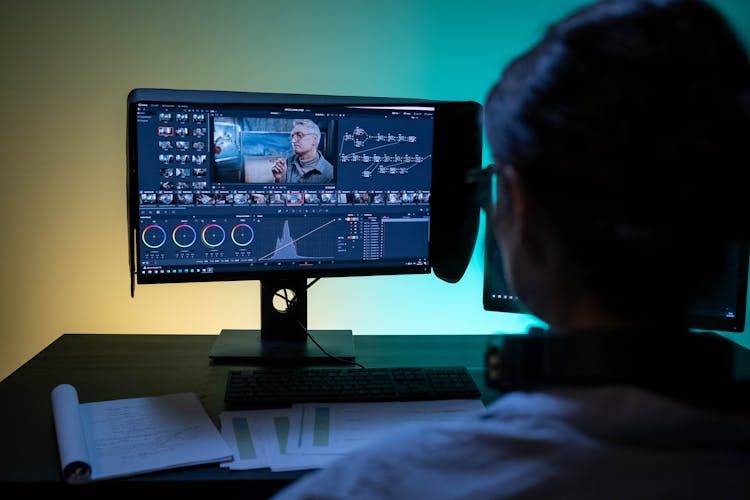 Backview Of A Female Editor Working On A Computer