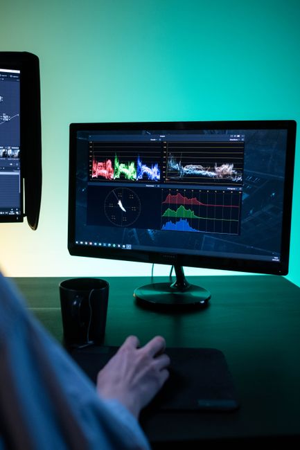 Fotomural Configuración moderna de espacio de trabajo con monitores duales mostrando software de edición y análisis de datos.