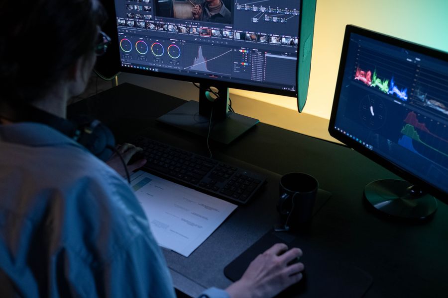Editor reviewing footage on a timeline in a dim edit suite