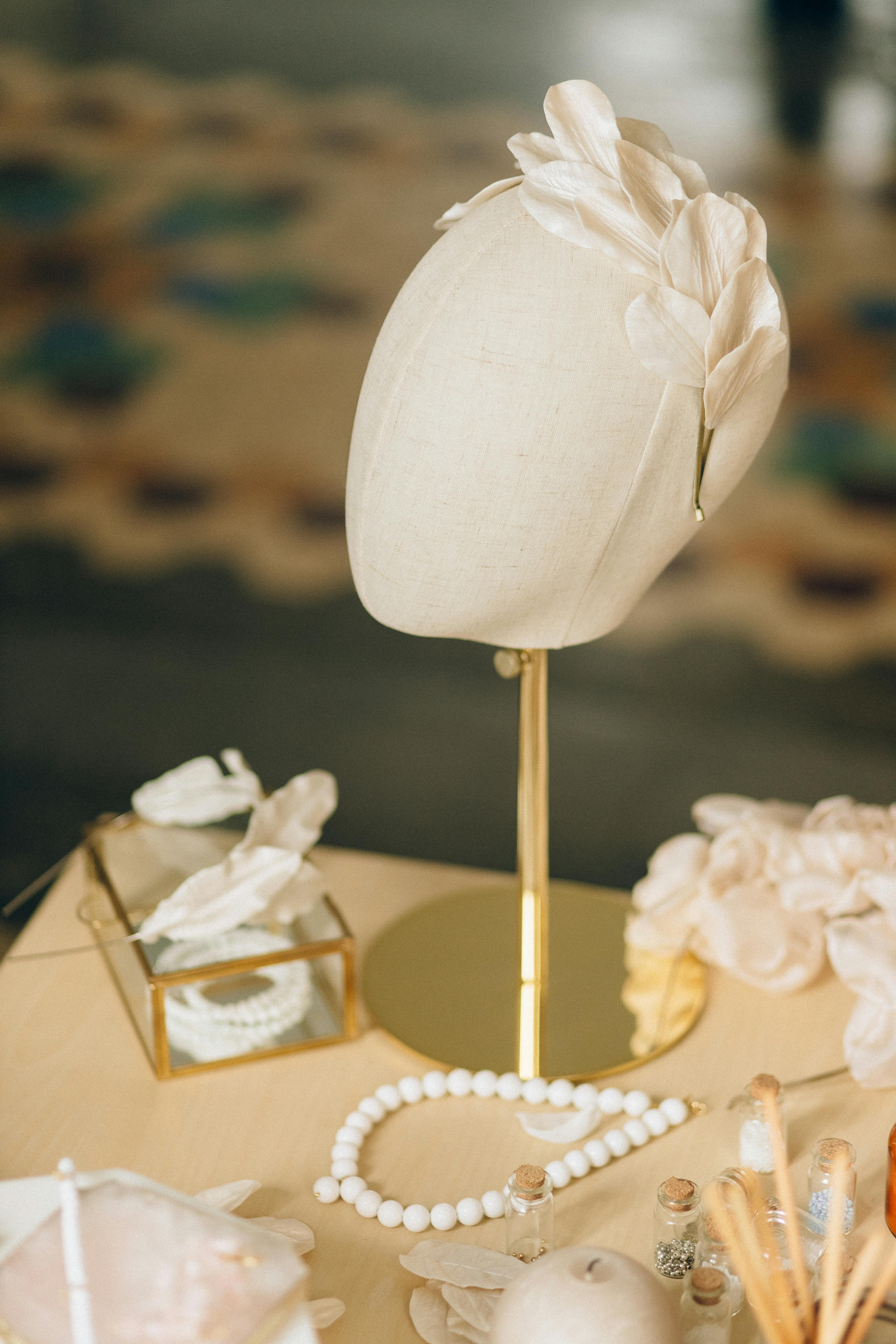 Chic floral headpiece on mannequin with delicate accessories, embodying elegance and style.