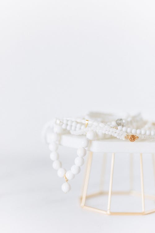 Free White Pearl Necklace on White Surface Stock Photo