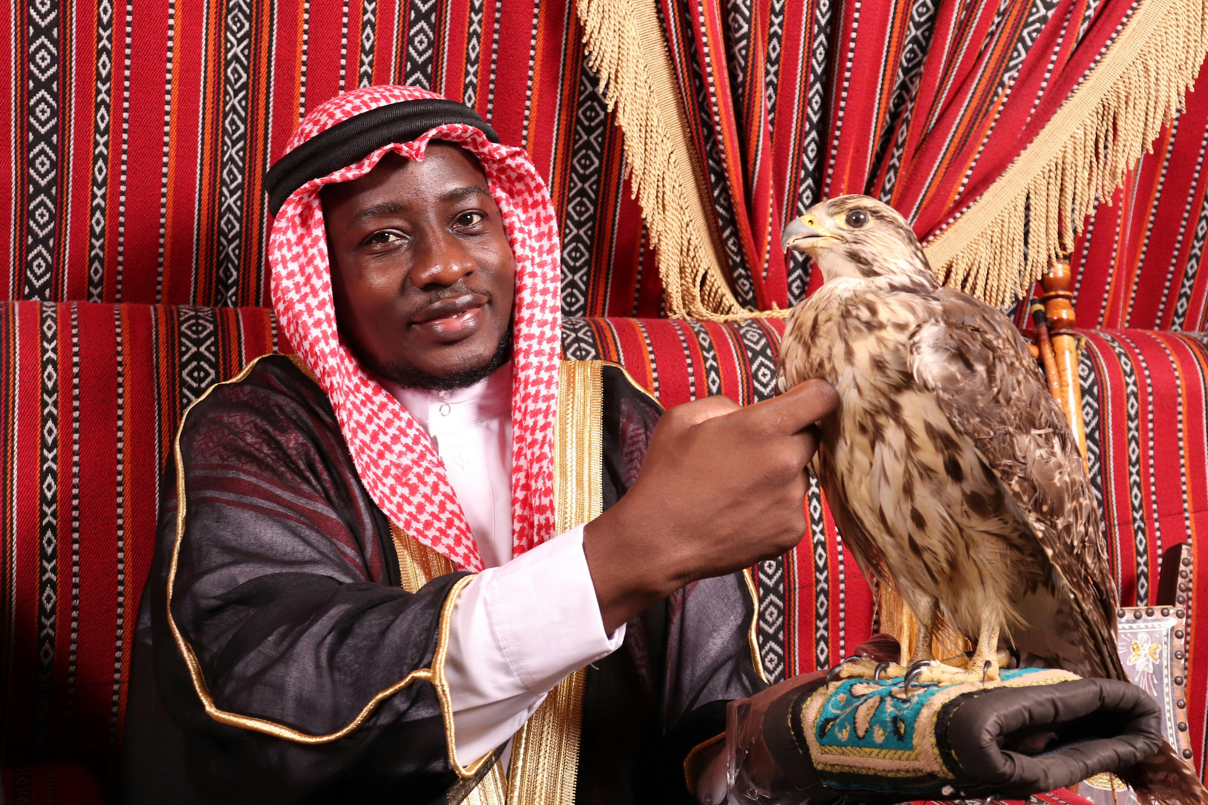 man wearing keffiyeh touching a bird