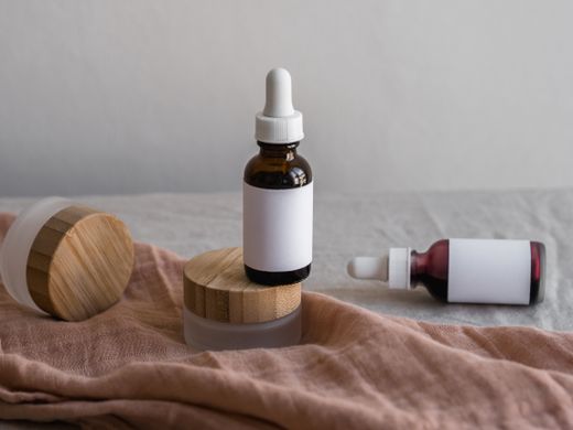 Dropper bottles with blank labels on linen — photo by Polina on Pexels