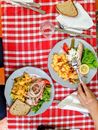 Person Holding Stainless Steel Fork and Knife on White Ceramic Plate