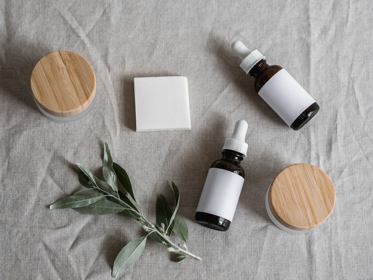 Marigold Hollow balms, serums and body butters laid out on natural linen — photo by Polina on Pexels