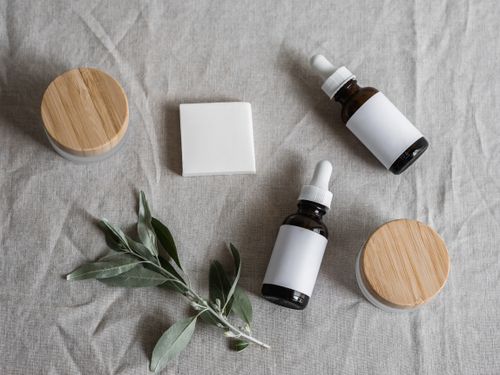 Free Top view of skincare products with a natural theme, featuring bottles, jars, and a plant on linen cloth. Stock Photo