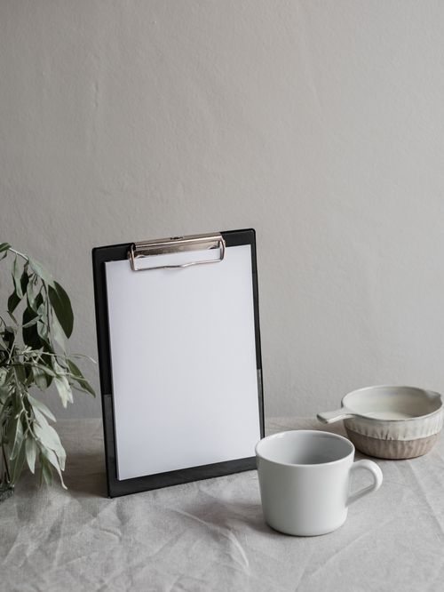 Free Elegant minimalist setup featuring a clipboard and mug on a textured surface for stylish organization. Stock Photo