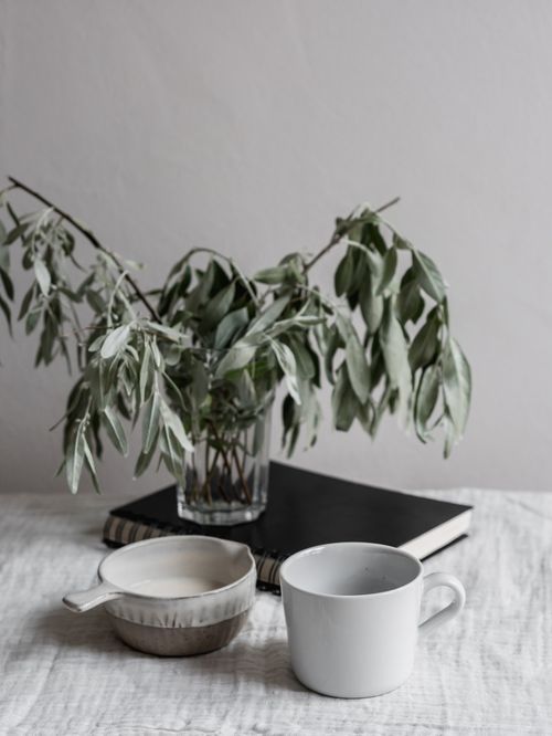 Free A serene still life featuring mugs, a vase with sage leaves, and a notebook. Stock Photo