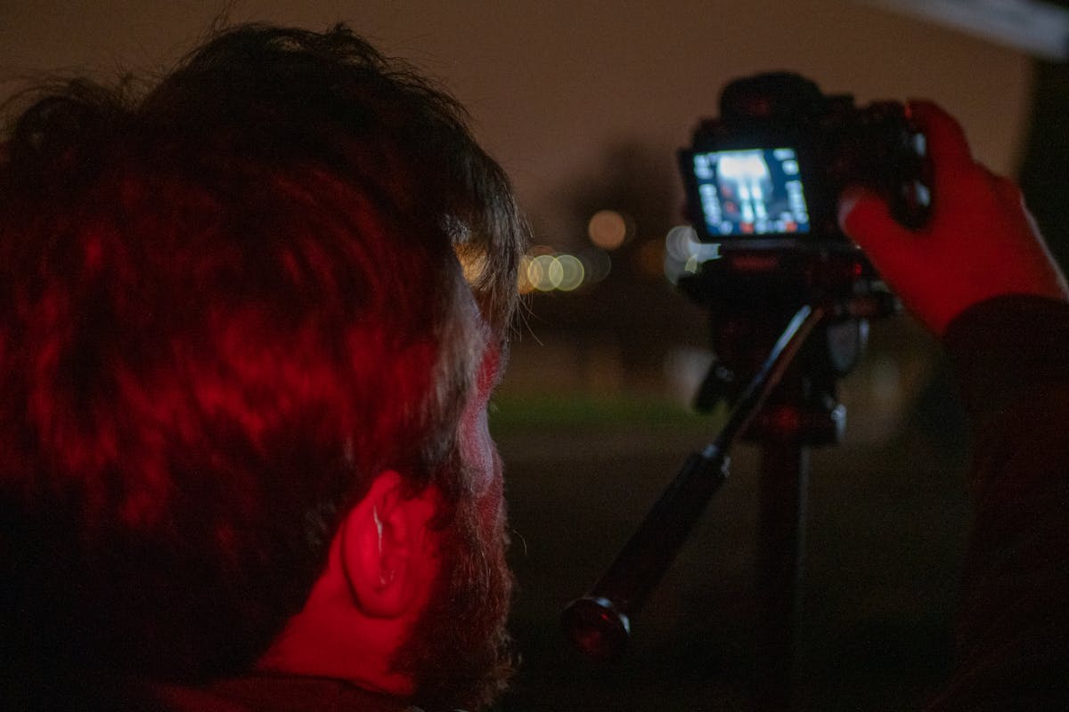 Hand pouring milk foam into a mug of coffee to create a latte, seen from above
