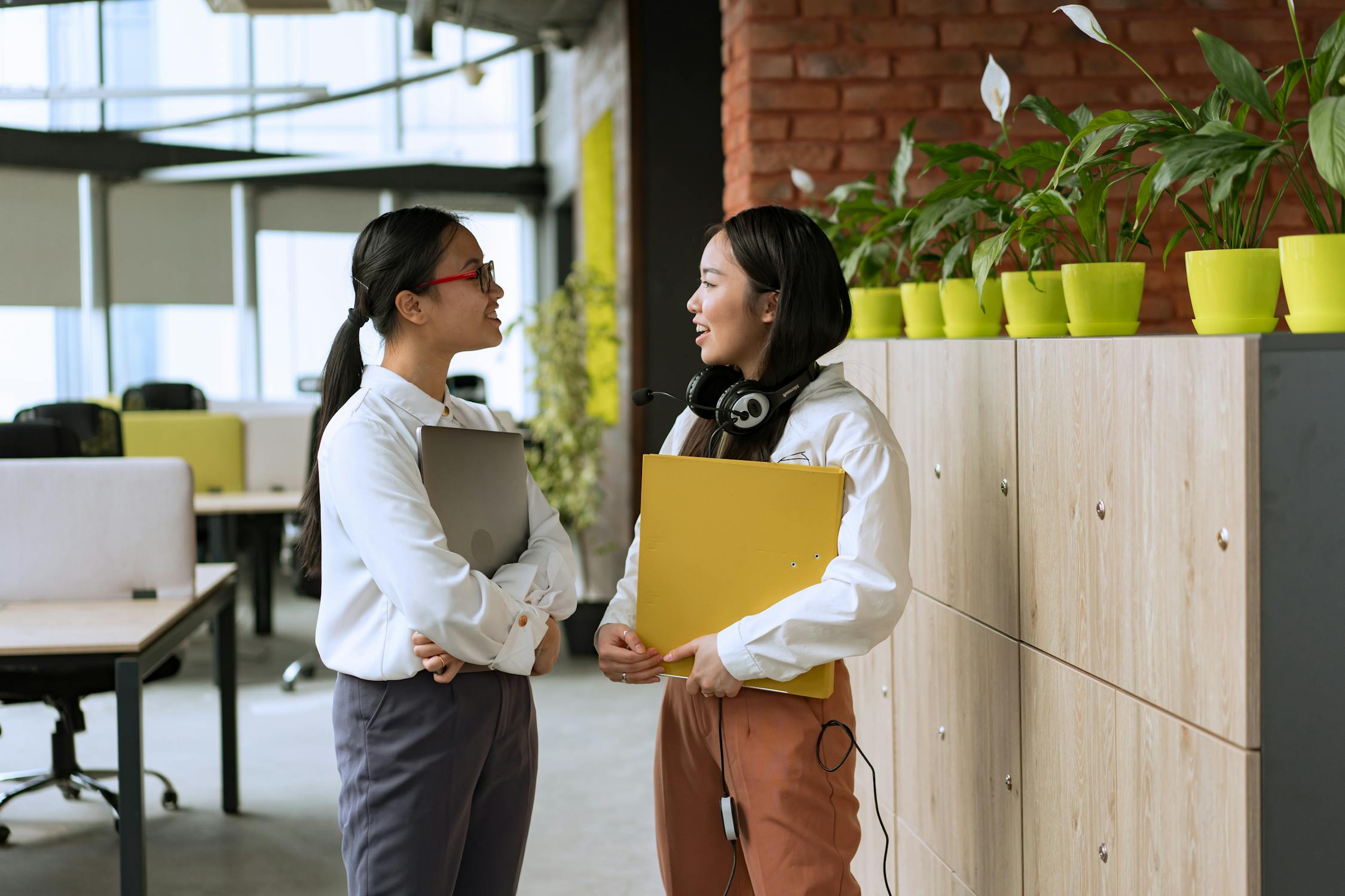 Image of two office workers smiling and talking. 