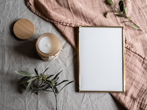 Free Empty Photo Frame Beside a Candle in a Glass Jar Stock Photo