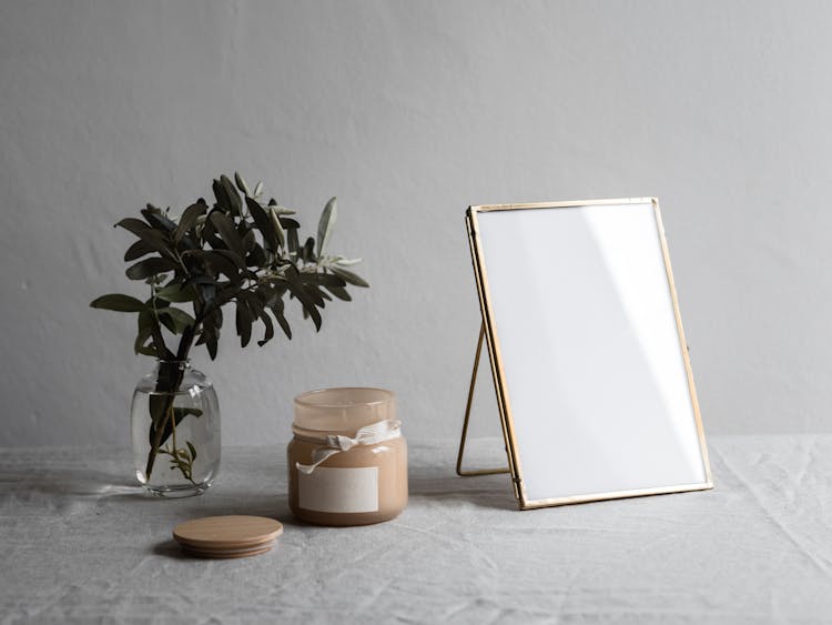 A Blank Photo Frame And Plant On The Table