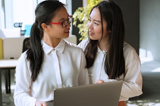 Two women collaborating and sharing ideas in a bright modern office.