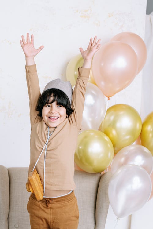 Free Boy in Brown Long Sleeve Shirt Smiling with Arms Raised Stock Photo