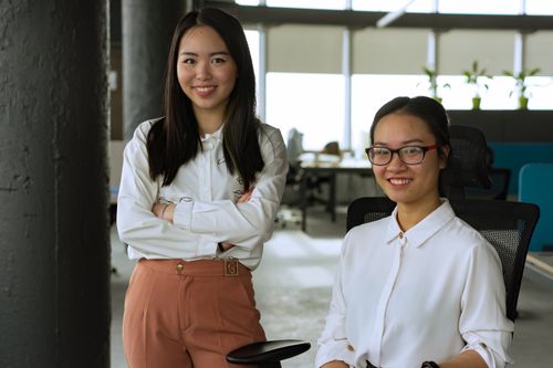 Free Two smiling women in an office, showcasing diverse workplace dynamics. Stock Photo