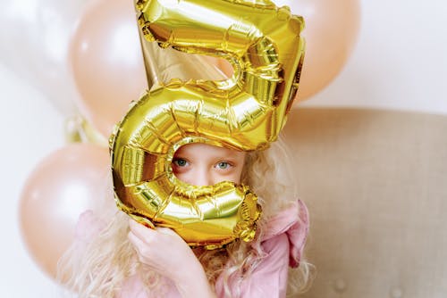 Kid Holding Balloon Near Her Face