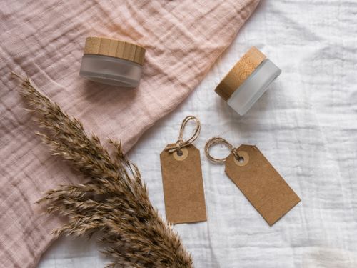 Free A rustic flatlay featuring jars with wooden lids and eco-friendly gift tags on textured fabric. Ideal for branding. Stock Photo